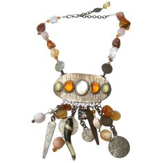 Phillipe Ferrandis Paris Artisan glass stone dangling charm necklace c 1980s The exotic burnished silver-tone necklace is comprised of a collection of smooth glass stones, translucent crystals, resin cabochons with series of dangling burnished silver metal mock coins The large-scale statement necklace makes a rattling sound from the collection of dangling embellishments Designed by Phillipe Ferrandis Measurements The necklace maximum length measured flat end to end = 21 in The necklace length ex Vintage Pendant Jewelry With Stones, Bohemian Amber Jewelry With Large Pendant, Vintage Pendant Jewelry With Natural Stones, Vintage Pendant Necklace With Natural Stones, Metal Dangle Necklaces With Natural Stones, Metal Necklaces With Natural Stones Dangle, Vintage Metal Jewelry With Natural Stones, Vintage Metal Necklace With Stones, Collectible Bohemian Amber Jewelry