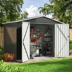 a metal shed with its doors open in the yard