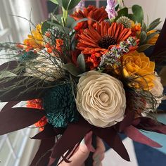 a person holding a bouquet of flowers in their hand