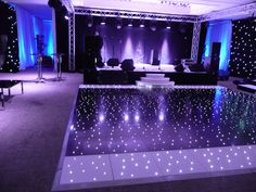 an indoor dance floor with blue lights on it