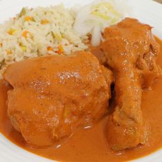 a white plate topped with meat covered in gravy and rice