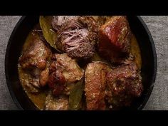 a pan filled with meat and vegetables on top of a table