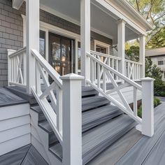 a porch with white railings and steps leading to the front door