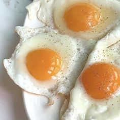 three fried eggs sitting on top of a white plate