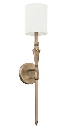 an antique brass finish wall light with a white shade on the top and bottom corner