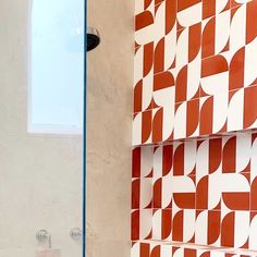 a bathroom with red and white tiles on the wall