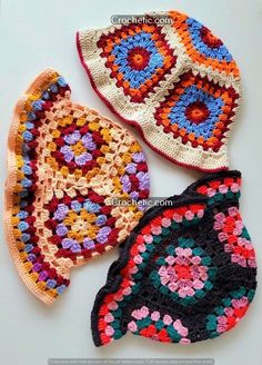 three crocheted potholders are sitting on a table together, one is multicolored and the other has flowers