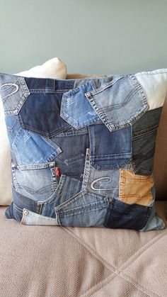 a pillow made out of jeans sitting on top of a couch