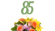 a vase filled with flowers next to a green number