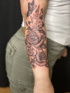 a woman's arm with roses and butterflies on it