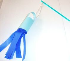 a toothbrush is hanging on the wall next to a blue tube with a green handle