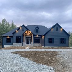 a blue house with lights on the front door and windows in the back ground area