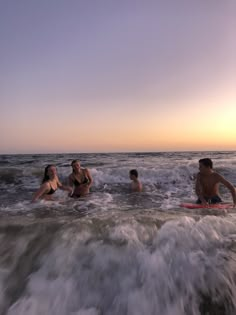 some people are in the water and one is on a surfboard