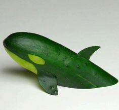 a cucumber shaped like a fish on a white surface