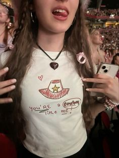 a woman with long hair wearing a hat and holding her cell phone in one hand