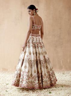 Editor's Note Presenting a luxurious ivory dupion silk lehenga set adorned with intricate floral thread embroidery, elegantly highlighted with various embellishments. This captivating ensemble is paired with an embroidered blouse and dupatta, creating a regal and elegant look perfect for special occasions or sophisticated gatherings. The rich texture of the dupion silk, the delicate embroidery, and the ornate details on both the blouse and dupatta add a touch of opulence, making this outfit a st Shraddha Kapoor In Lehenga White, Bollywood Lehenga Outfit Ideas, White Patola Saree, Floral Embroidery Lehenga, Lehenga White, Floral Thread Embroidery, Embroidery Lehenga, Banarasi Lehenga, Haldi Outfit