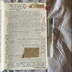 an open book with writing on it next to a pen