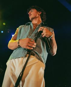 a man holding a microphone on top of a stage