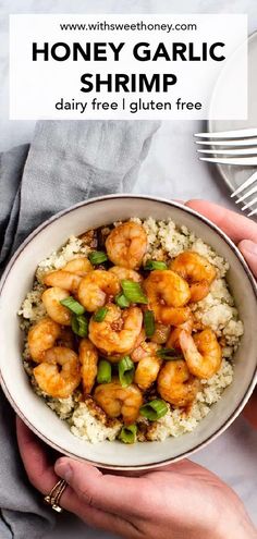 a bowl filled with shrimp and rice on top of a white plate next to silverware