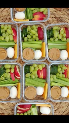 several plastic containers filled with vegetables and dips on top of a grass covered field