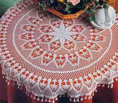 a crocheted tablecloth with flowers on it