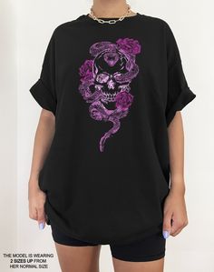 We are loving this skull skeleton vintage aesthetic tee. Its such a cute addition to any pastel goth clothing collection. It even gives romantic & soft goth vibes! We suggest going 1-2 sizes up from your normal size to get an oversized look like the photos. This cotton tee has the classic cotton look and feel and fits like a well-loved favorite. It's soft, cozy, and a great trendy addition to your wardrobe! Super soft cotton and excellent quality print makes you fall in love with it over and ove Edgy Skull Print T-shirt For Alternative Fashion, Alternative Skull Print T-shirt For Halloween, Skull Print T-shirt For Alternative Fashion, Skull Print Short Sleeve T-shirt For Alternative Fashion, Skull Print Graphic Tee For Alternative Fashion, Alternative Style Skull Print T-shirt, Graphic Tee Tops With Skull Print For Alternative Fashion, Graphic Tee With Skull Print For Alternative Fashion, Short Sleeve T-shirt With Skull Print For Alternative Fashion