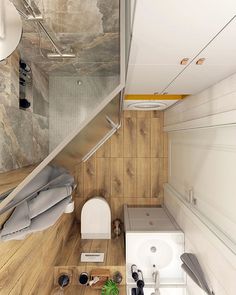 small bathroom with wood flooring and white fixtures in the shower area is shown from above