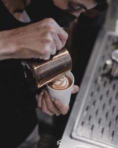 a person pouring coffee into a cup