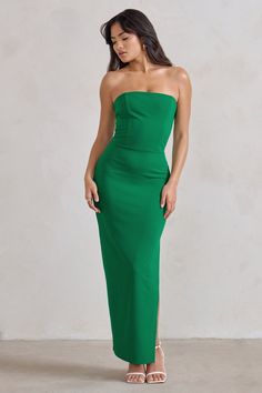 a woman wearing a green strapless dress with high slits on the side and one leg