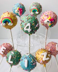 cake pops with rainbow frosting and sprinkles are arranged in the shape of numbers