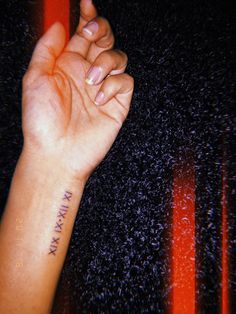 a woman's arm with a small tattoo on her left wrist and the word mama written in cursive writing