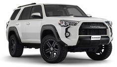 the front end of a white toyota 4runner with black rims and tires on