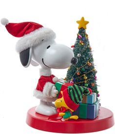 a snoopy christmas figurine is holding a present