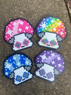 four pixelated coasters are sitting on the ground, each with different colored designs