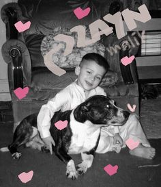 a young boy sitting on the floor with two dogs in front of him and hearts flying around him