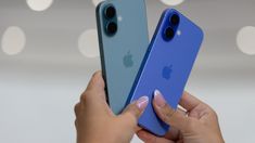 two women holding up their new iphones in front of the camera, one blue and one green