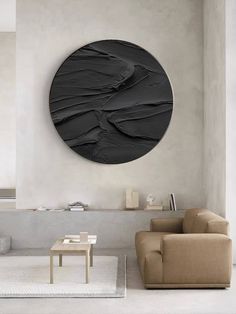 a living room with couches, tables and a large circular wall art on the wall