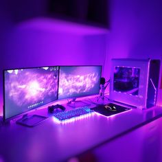 two computer monitors sitting on top of a desk in front of a keyboard and mouse