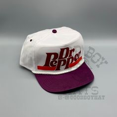 a white and purple hat with the word dr pepper on it's front side