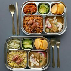 two metal trays filled with different types of food next to silver utensils