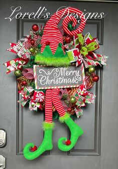 a christmas wreath on the front door with stockings and candy canes hanging from it