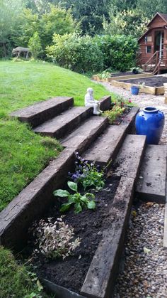 an outdoor garden with steps leading up to the house