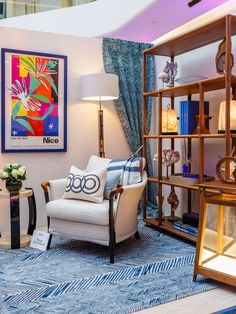 a living room filled with furniture next to a tall book shelf full of books and vases