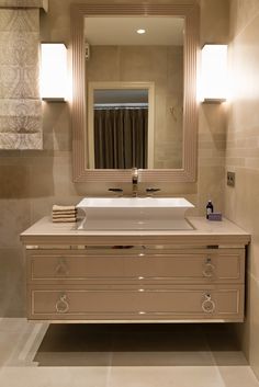 a bathroom with a sink, mirror and towel rack in it's center area