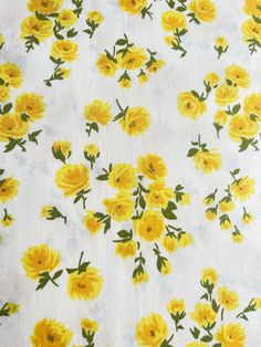 yellow flowers on white fabric with green leaves