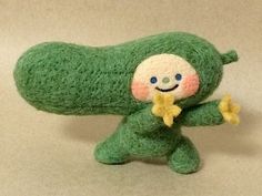 a green stuffed animal with a smile on it's face