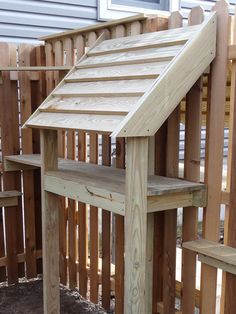 a wooden bench sitting on top of a yard next to a fence and building materials