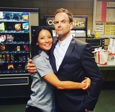 a man and woman hugging each other in front of vending machines