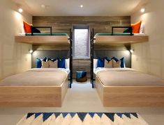 two bunk beds in a small room with lights on the ceiling and pillows on the floor