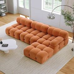 an orange couch sitting on top of a white rug